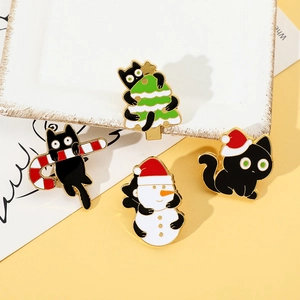 Close-up of four cute black cat Christmas enamel pins with festive gold plating details