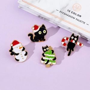 Detailed view of four festive Christmas black cat enamel pins with gold metal edges