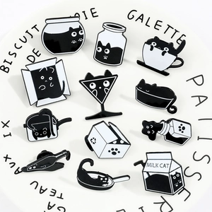 Gros plan détaillé de pin's en émail chat noir présentés sur une assiette décorative en porcelaine