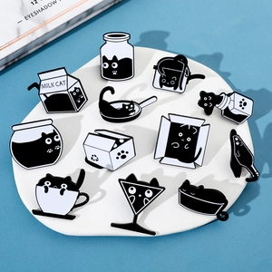 Vue à plat de 12 pin's créatifs en émail chat noir exposés sur une pierre de marbre