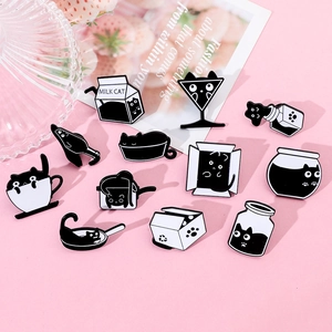 Détail de broches chat en émail dans des boîtes de lait sur un fond décoratif rose