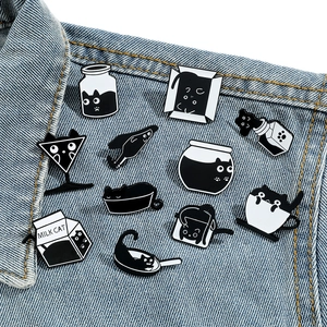 Broches créatives en émail de chats noirs liquides épinglées sur une veste en jean bleu