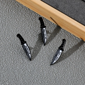 Macro detail of three enamel dagger pins with feminist slogans on silver-tone zinc alloy metal