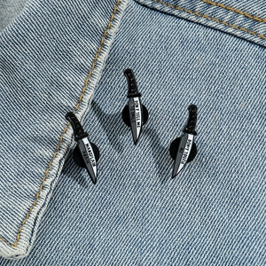 Three-piece feminist dagger enamel pin set with slogans on denim jacket lapel