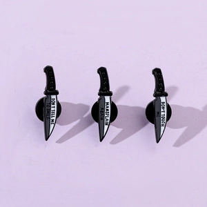 Detailed close-up of feminist dagger enamel pins with feminist slogans on lavender background
