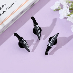 Detailed view of feminist enamel dagger pins featuring Don't Touch Me slogan in black and white