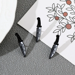Detailed view of three enamel dagger pins with Don't Touch Me and feminist slogans