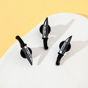 Three-piece set of dagger enamel pins with feminist slogans on a yellow background