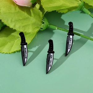 Macro detail of three enamel dagger pins featuring feminist slogans on green background