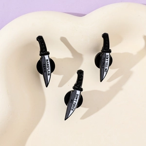 Three enamel dagger pins in a tray with phrases Don't touch me and Mansplain again