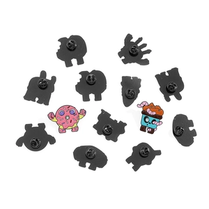 Set of cartoon monster enamel pins showing donut designs and black metal back fasteners