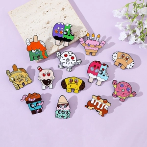 Flat lay of colorful monster dessert enamel pins on a lavender background with floral decor