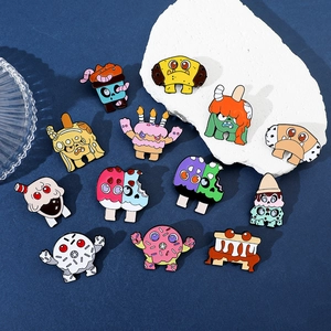 Detail shot of twelve cute enamel monster pins featuring dessert-themed monster designs