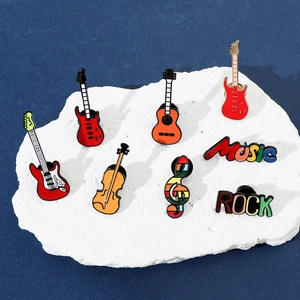 Gros plan détaillé de pin's émaillés thème musique avec guitares et violon colorés