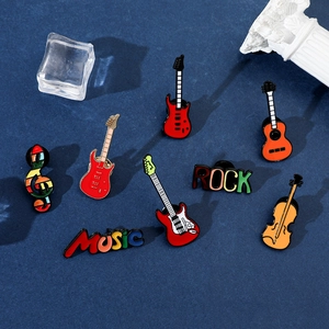 Gros plan de pin's émaillés d'instruments de musique dont guitares et violons