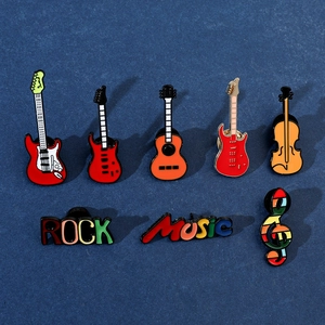 Vue détaillée de huit broches émaillées musique avec guitares et notes sur tissu bleu
