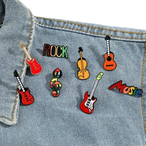 Set de pin's émaillés musique avec guitares et notes sur une veste en jean bleue