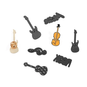 Détails des épinglettes musicales en émail montrant la texture du métal et le fermoir papillon