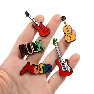 Détail de cinq épinglettes en émail rock music avec guitares électriques et lettrage