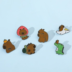 Collection de six pin's mignons en émail capybara avec fraise et tortue sur fond bleu