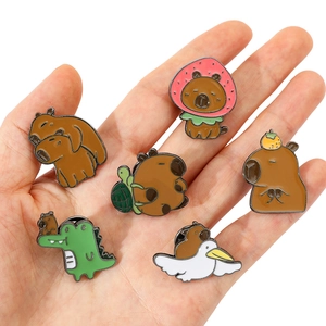 Ensemble détaillé de six broches mignonnes en émail de capybara tenues dans la main