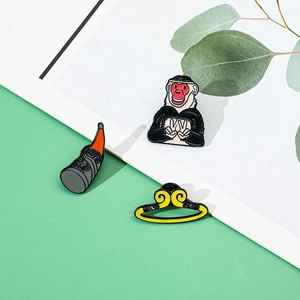 Close-up of three-piece enamel pin set featuring Monkey King and his golden hoop crown