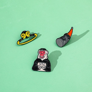 Detailed close-up of Monkey King enamel pins set with headband and golden cudgel