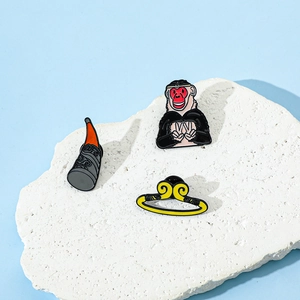 Detailed view of three enamel Monkey King pins on stone base featuring headgear and staff