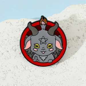 Macro detail of round Baphomet enamel pin with grey demon and red border design
