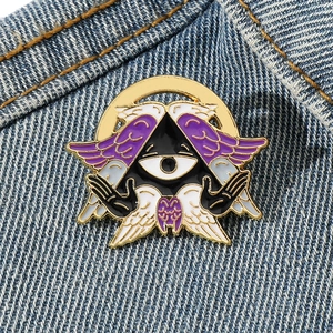 Cartoon Cthulhu Angel metal enamel pin with all-seeing eye on blue denim jacket