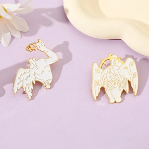 Artistic white enamel angel wings and eyeball pin badges on a ceramic tray