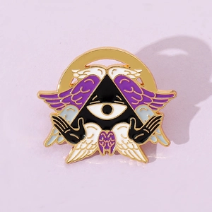 Macro shot of mystic All Seeing Eye enamel pin with purple wings and golden alloy edges