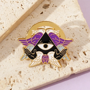 Close-up of All-seeing Eye enamel pin with purple wings and gold metal plating