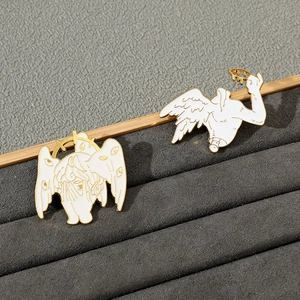 Macro detail of white enamel Seraphim angel brooches with intricate golden wing textures