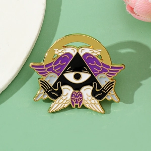 Detailed close-up of a Cthulhu angel enamel pin with purple wings and golden finish