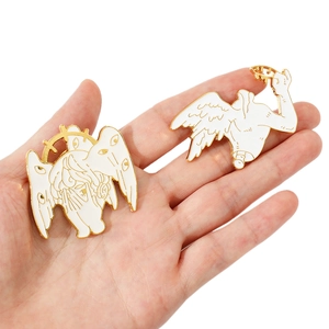 Macro view of white enamel Seraphim and Cthulhu metal pins held in hand to show size