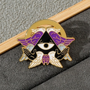 Close-up of Cthulhu angel enamel pin with purple wings and golden eye detail