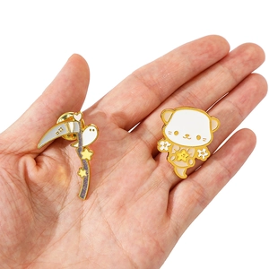 Nahaufnahme von Halloween-Emaille-Pins mit Geisterkatze und Sense mit Metalldetails