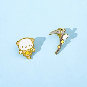 Detail von Emaille-Pins mit Otter und Stern sowie Sense mit Geist auf blauem Hintergrund