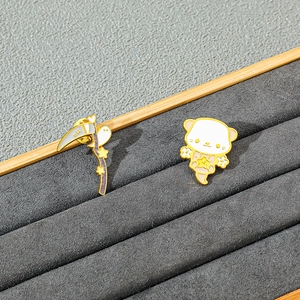 Detailansicht der Emaille-Pins mit Sense und Geist auf einem grauen Schmucktablett
