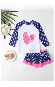 Close-up of kids' two-piece polka dot swimsuit with pink heart and ruffled skirt