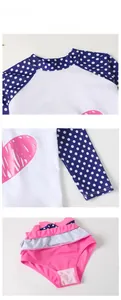 Detail view of pink heart print swimsuit with polka dot sleeves and ruffled bikini bottom