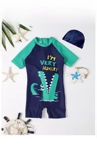 Detail of boys' short sleeve dinosaur swimsuit with matching cap and cute crocodile print