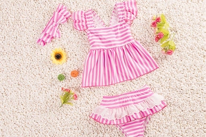 Detailed flat lay of toddler navy stripe three-piece swimsuit with lace skirt and headband