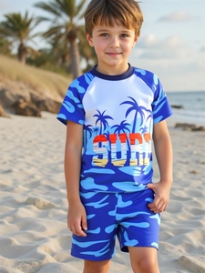 Detail of boys' quick-dry swimwear featuring coconut tree print and SURF lettering on beach