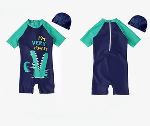 Detail showing kids navy swimwear with green crocodile print and matching swim cap