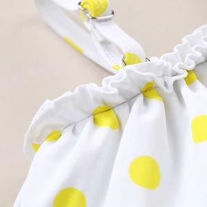 Detail of yellow polka dot swimsuit featuring ruffled edges and adjustable shoulder straps