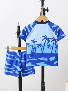 Detailed view of kids' two-piece swimsuit featuring tropical coconut tree print