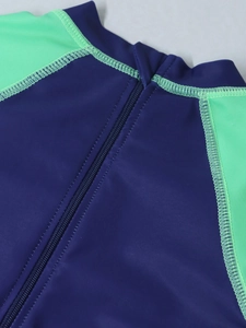 Dettaglio costume da bagno bimbo con cerniera frontale e cuciture verde neon