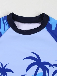 Detail of boys' swimwear with navy blue crew neck and palm tree pattern on quick-dry fabric